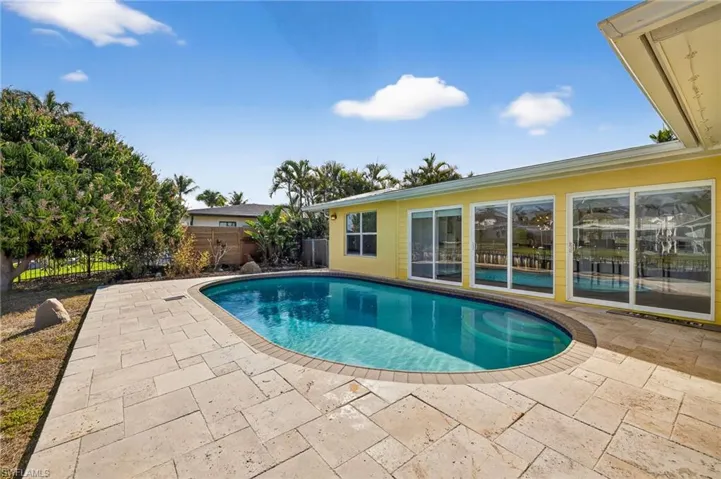 View of swimming pool with a fenced backyard and patio surround