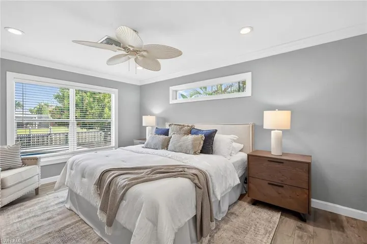 Bedroom with multiple windows, light wood finished floors, crown molding, ceiling fan, and recessed lighting