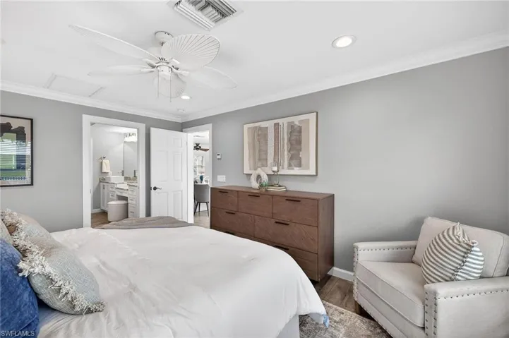 Bedroom with ornamental molding, recessed lighting, light wood finished floors, a ceiling fan, and ensuite bathroom