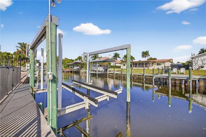 Dock area featuring boat lift and a water view