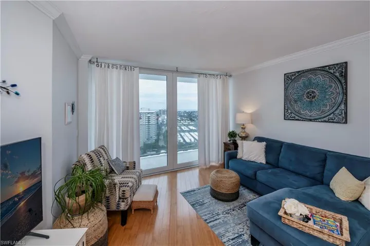 Living room with wood-type flooring and ornamental molding