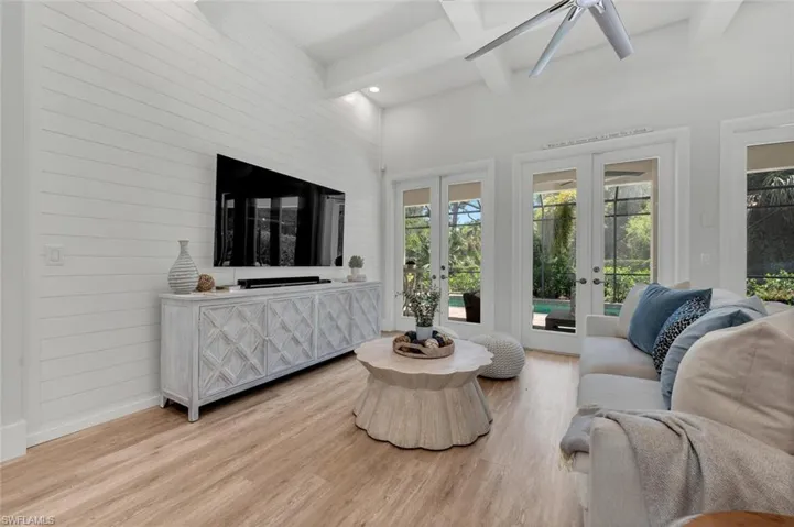 Living room featuring coffered ceiling, wood finished floors, beam ceiling, and french doors