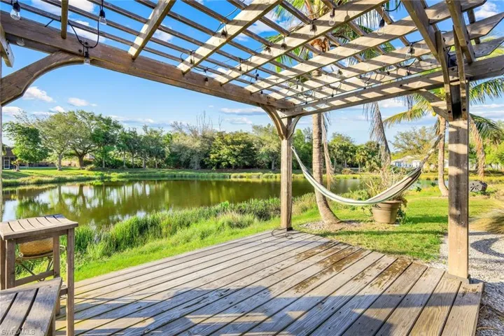 Wooden terrace featuring a pergola and a water view