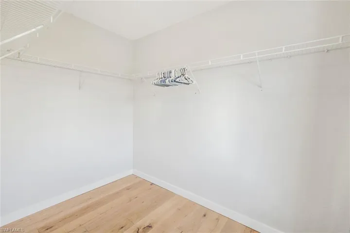 Walk in closet with light wood-style flooring