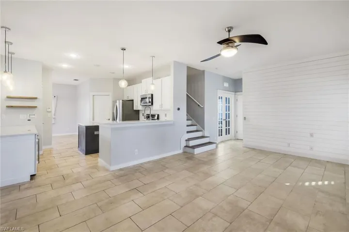 Kitchen featuring a peninsula, appliances with stainless steel finishes, white cabinets, light countertops, and ceiling fan