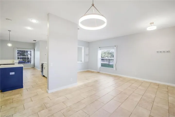 Unfurnished room with wine cooler and baseboards