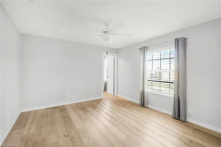 Empty room featuring baseboards, ceiling fan, and wood finished floors
