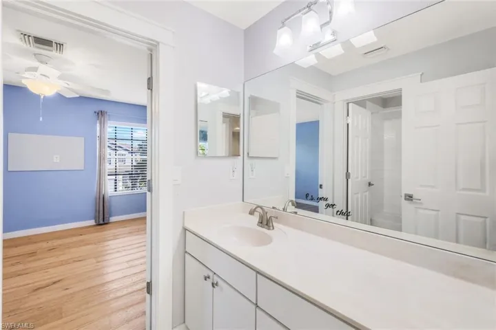 Full bathroom featuring visible vents, wood finished floors, baseboards, ceiling fan, and vanity
