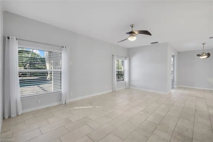 Unfurnished room with a ceiling fan, visible vents, and baseboards