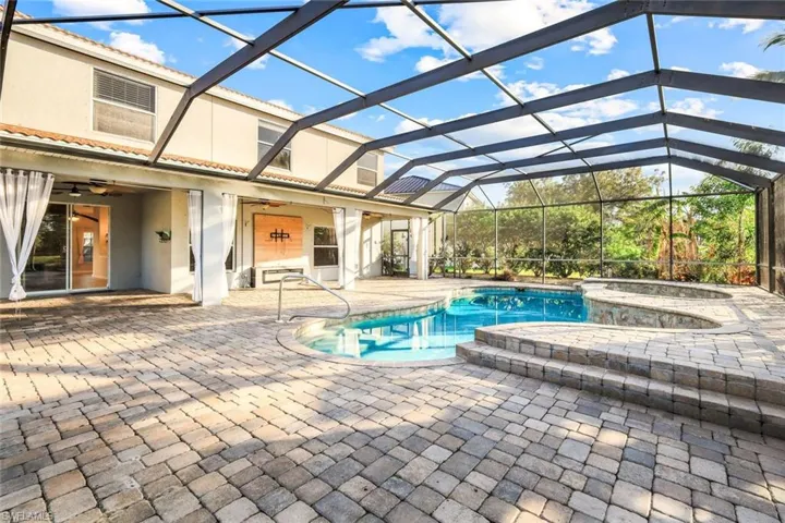View of pool with a patio, a ceiling fan, a pool with connected hot tub, and a lanai