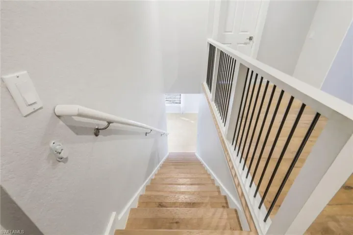 Stairway featuring baseboards and wood finished floors
