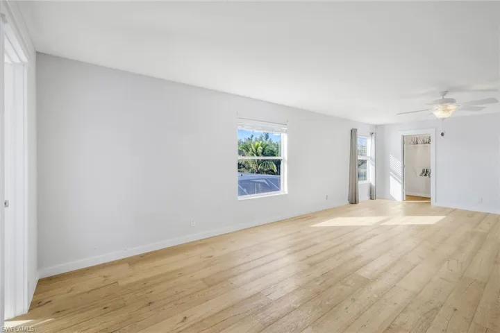 Unfurnished room with light wood-type flooring, baseboards, and a ceiling fan