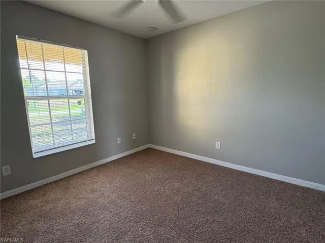 Empty room with carpet and a textured ceiling