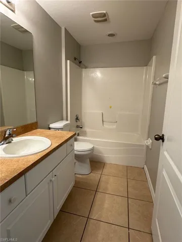 Full bath with light tile patterned floors, shower / bath combination, and vanity
