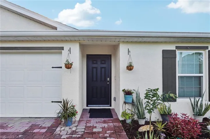Entrance to property with stucco siding and an attached garage