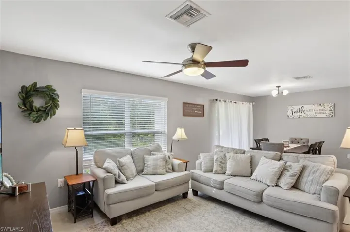 Living room with baseboards and a ceiling fan