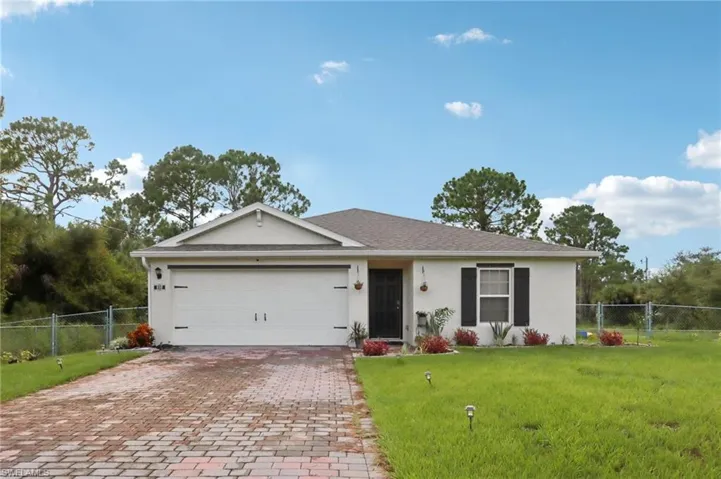 Ranch-style house with stucco siding, decorative driveway, a garage, and a gate