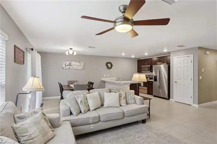 Living room with ceiling fan, recessed lighting, and light tile patterned floors