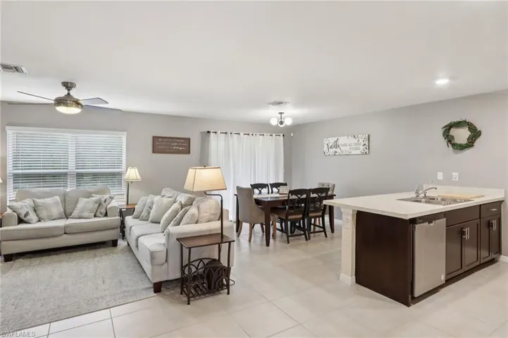 Living area with light tile patterned flooring and a ceiling fan