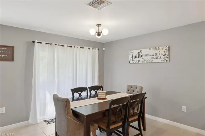 Dining room with light tile patterned flooring and a chandelier