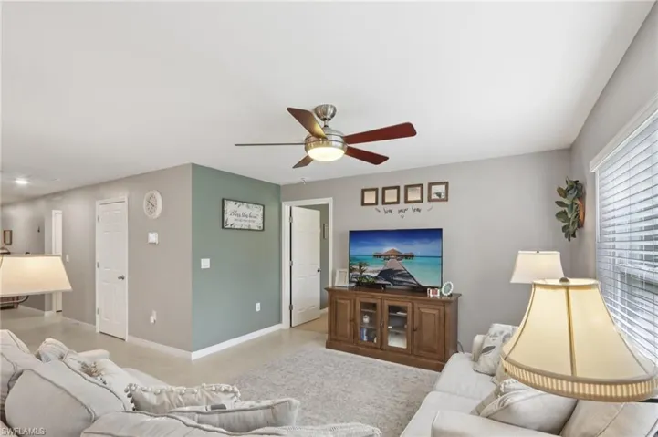 Living area with a ceiling fan and light tile patterned flooring
