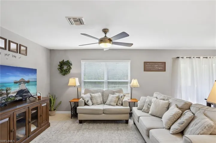 Living room with ceiling fan and baseboards