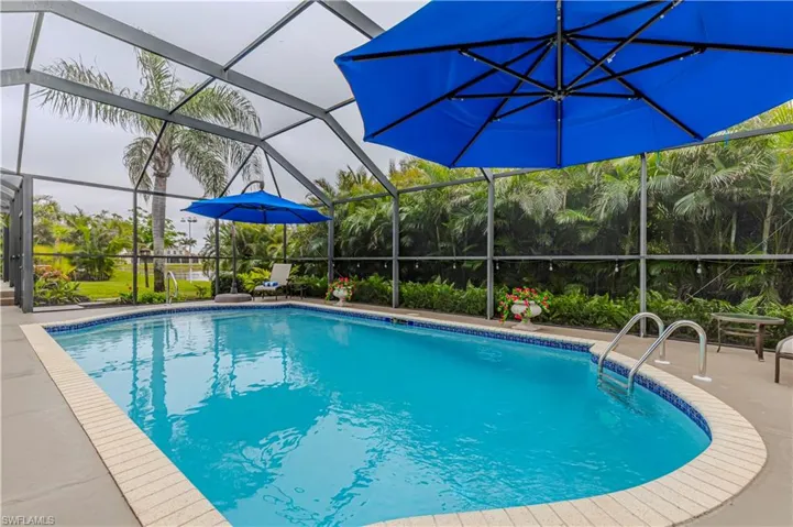 View of swimming pool with glass enclosure and a patio