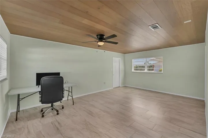 Unfurnished office with wooden ceiling and ceiling fan
