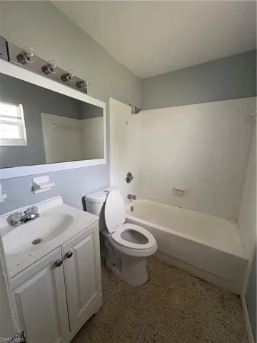 Bathroom with vanity,  shower combination, and dark speckled floor