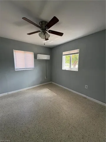 Unfurnished room featuring a ceiling fan and speckled floor