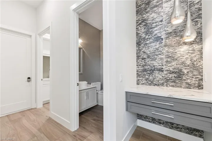 Half Bathroom for guest  with vanity and wood finished floors