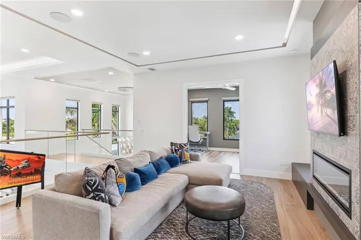 Living area with healthy amount of natural light, recessed lighting, light wood-style flooring, and a fireplace