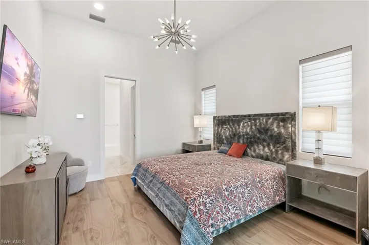 Bedroom with a chandelier and a towering ceiling