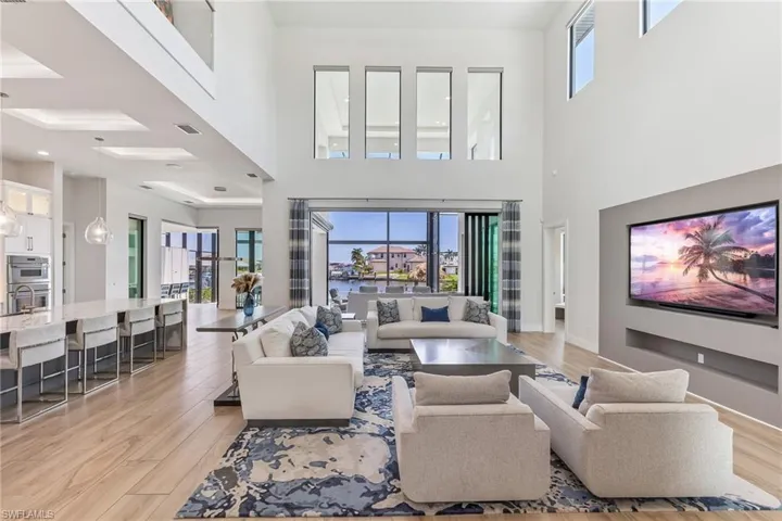 Living room featuring light wood-type flooring and a high ceiling