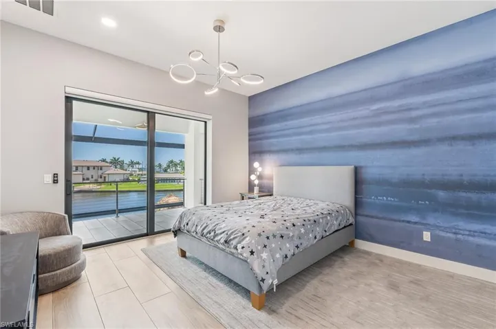 Bedroom featuring access to exterior and a chandelier