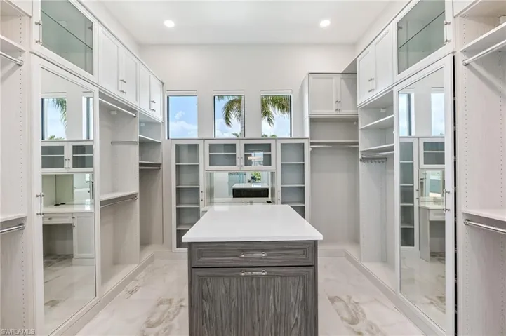 Spacious closet featuring light marble finish flooring