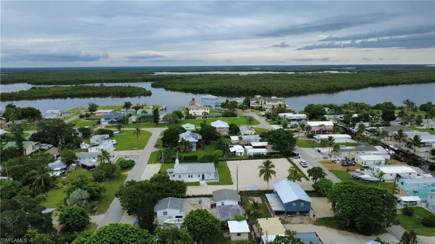 Aerial view of residential area with a large body of water and a forest