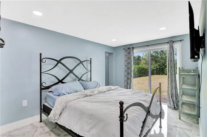 Bedroom with recessed lighting and light marble finish floors