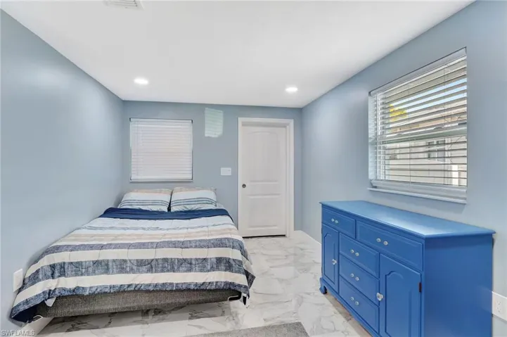Bedroom featuring recessed lighting and light marble finish floors