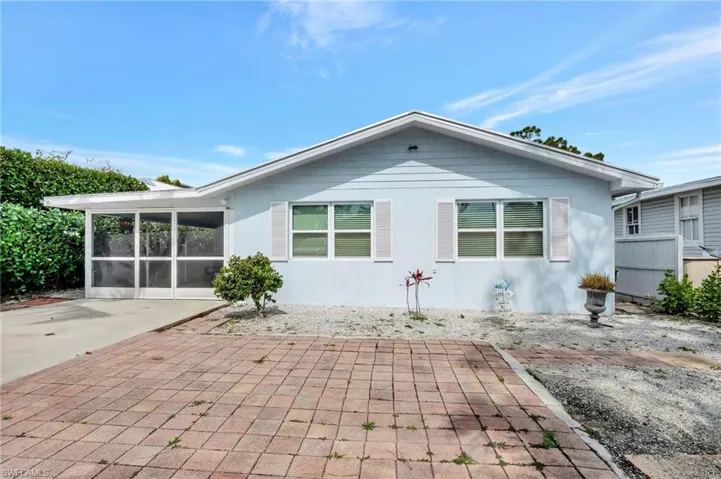 Rear view of house with a sunroom, a patio area, and stucco siding