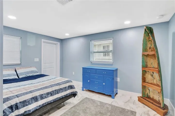 Bedroom with recessed lighting and light marble finish floors