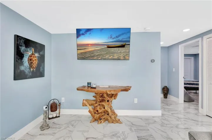 Hallway featuring light marble finish flooring and recessed lighting