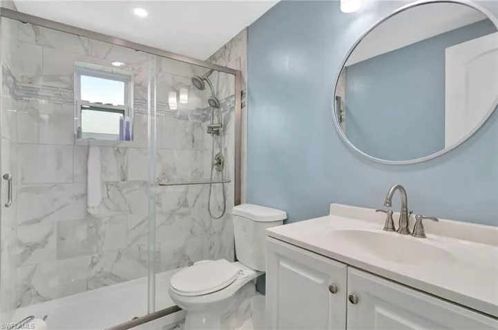 Full bath featuring vanity and a marble finish shower