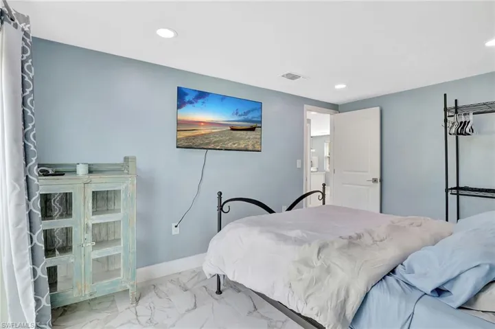Bedroom featuring marble look tiles and recessed lighting