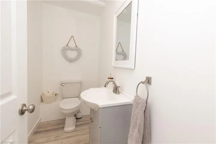 Half bathroom featuring vanity and light wood-type flooring