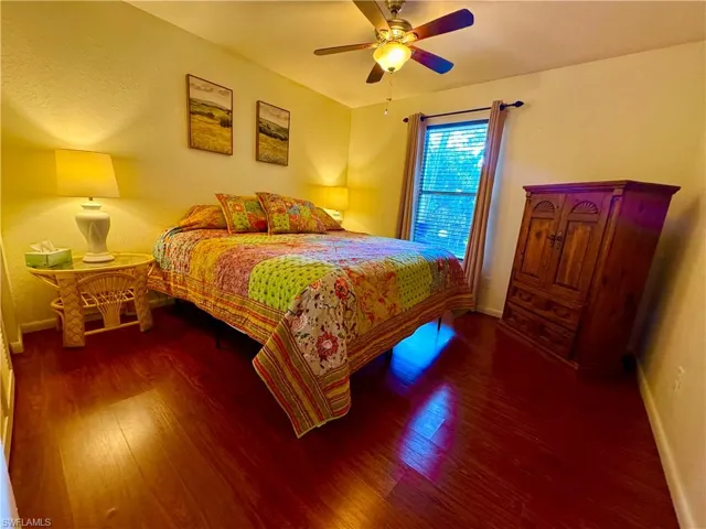 Bedroom featuring ceiling fan, baseboards, and wood finished floors