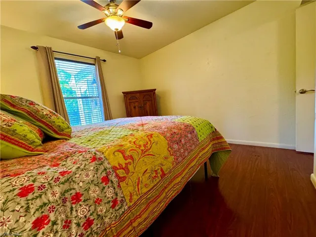 Bedroom with ceiling fan, wood finished floors, and baseboards
