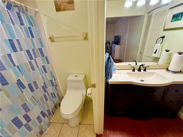 Full bathroom featuring tile patterned flooring, a shower with curtain, vanity, and toilet