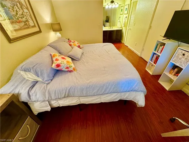 Bedroom with a sink, wood finished floors, and connected bathroom