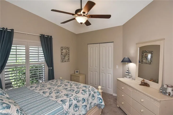 Bedroom with ceiling fan, a closet, carpet, and vaulted ceiling